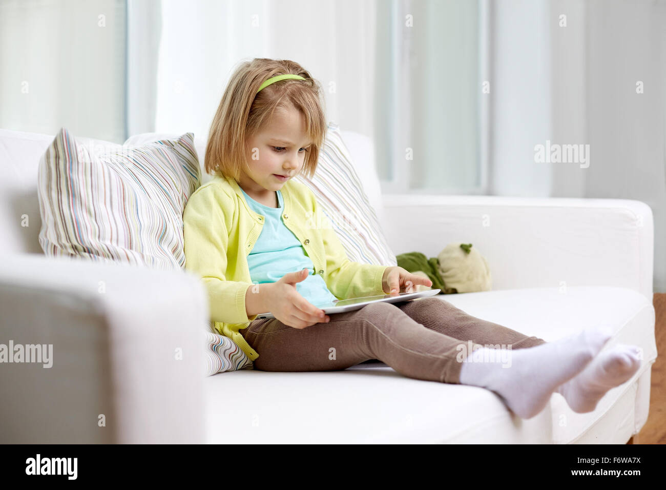 little girl with tablet computer at home Stock Photo - Alamy