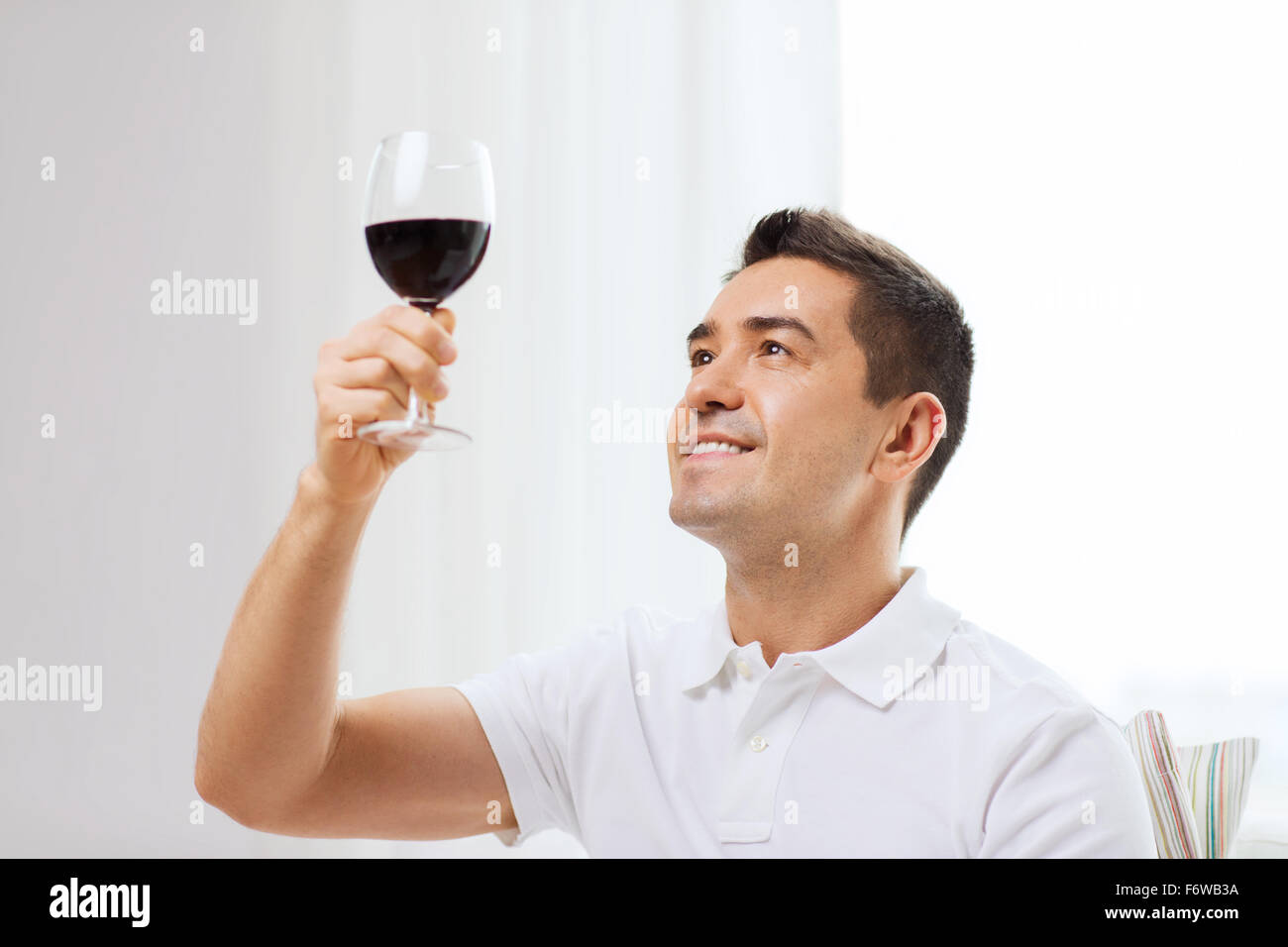 happy man drinking red wine from glass at home Stock Photo - Alamy