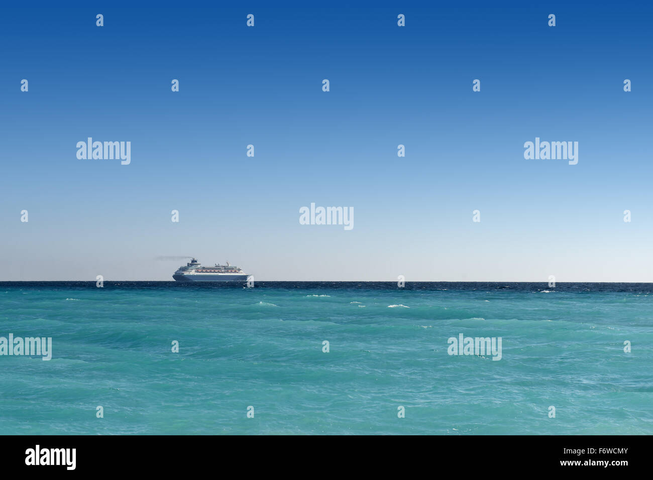 cruise liner sailing away on turquoise water and blue sky backround Stock Photo