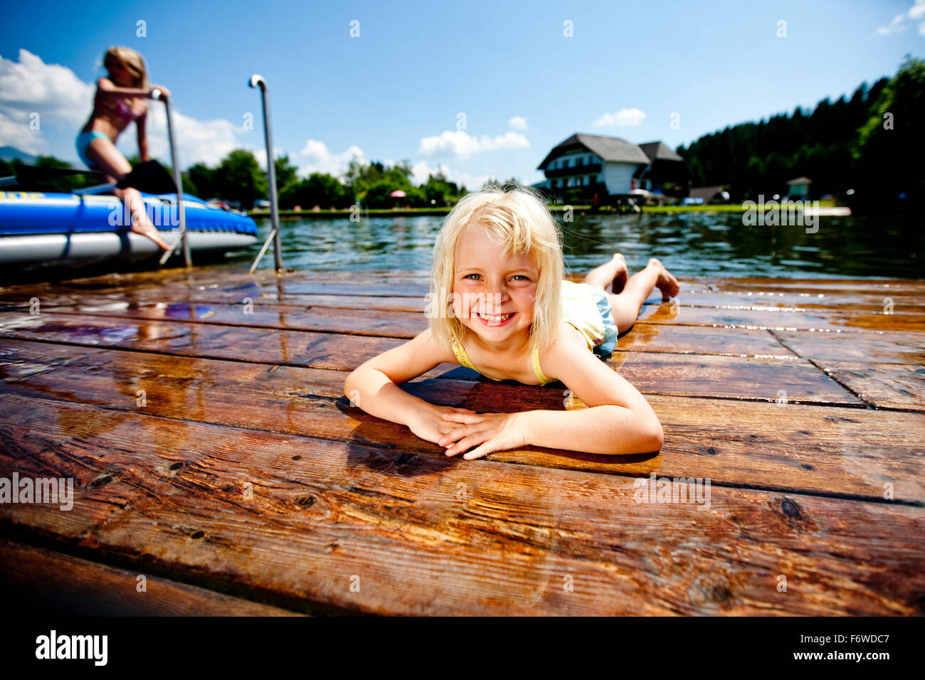 Girl lying on a jetty at Furtnerteich, Mariahof, Murtal, Styria, Austria Stock Photo