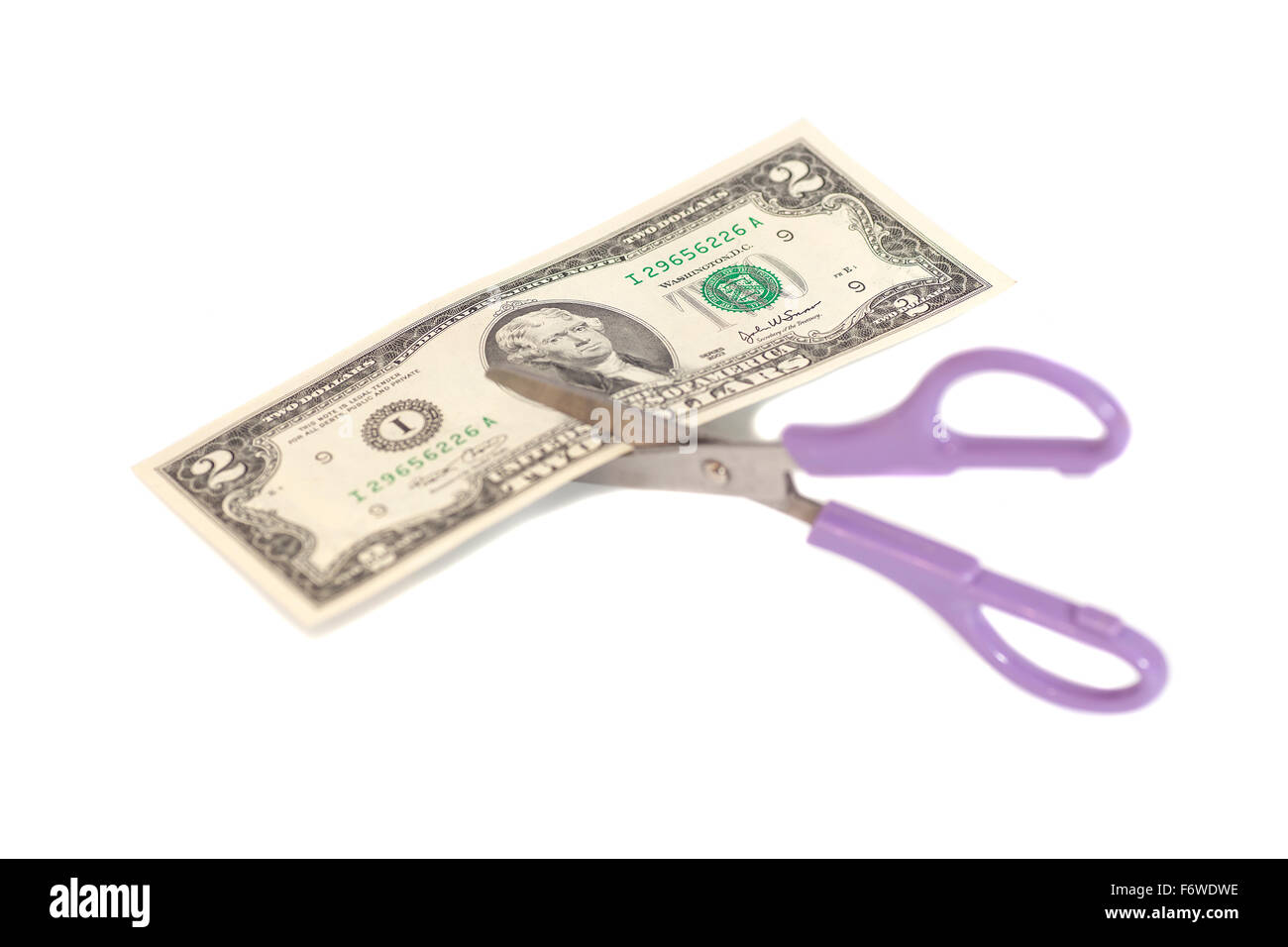 Two Dollars are cutting with scissors on white background.Business concept. Stock Photo