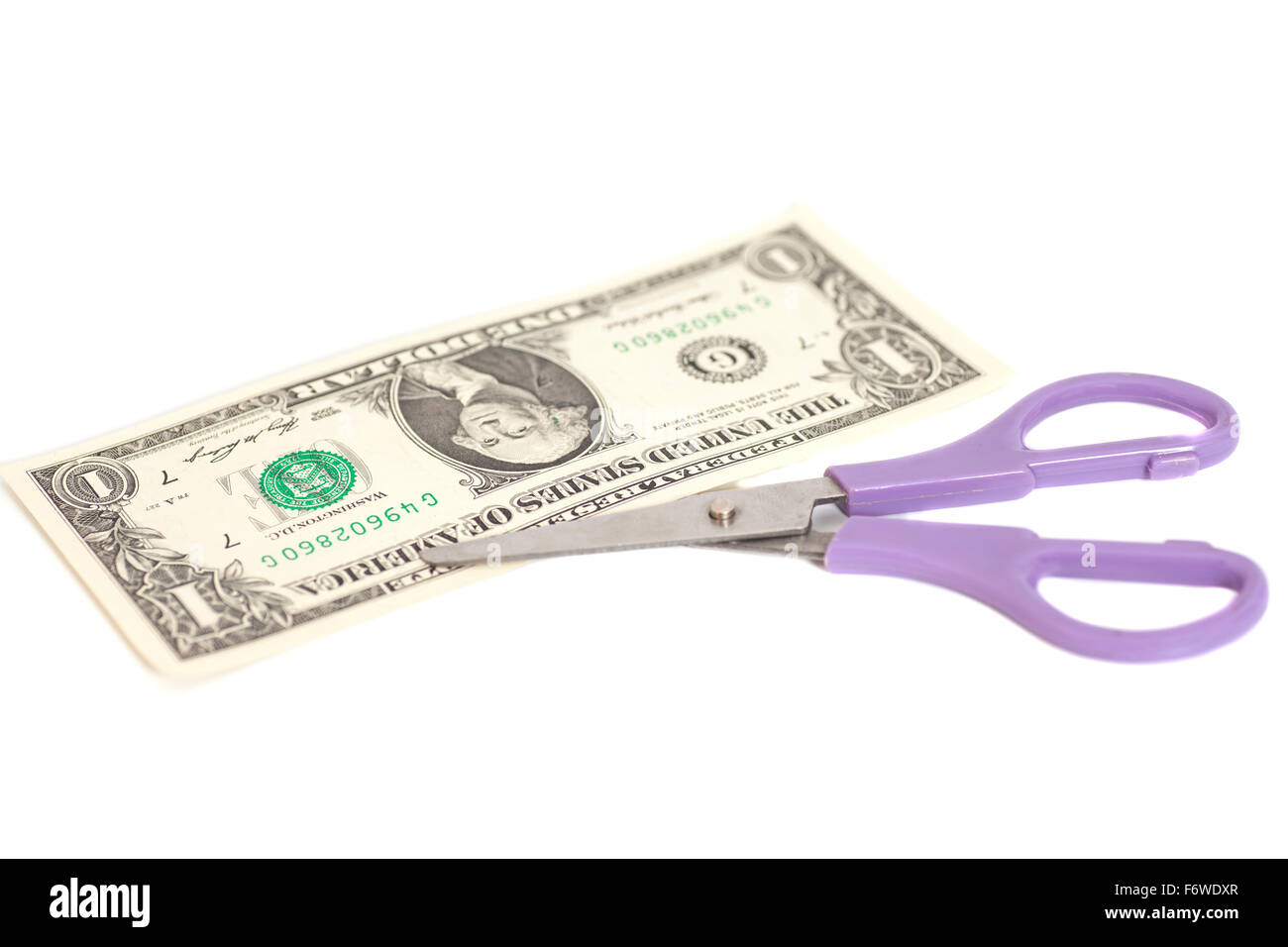 One Dollars are cutting with scissors on white background. Stock Photo