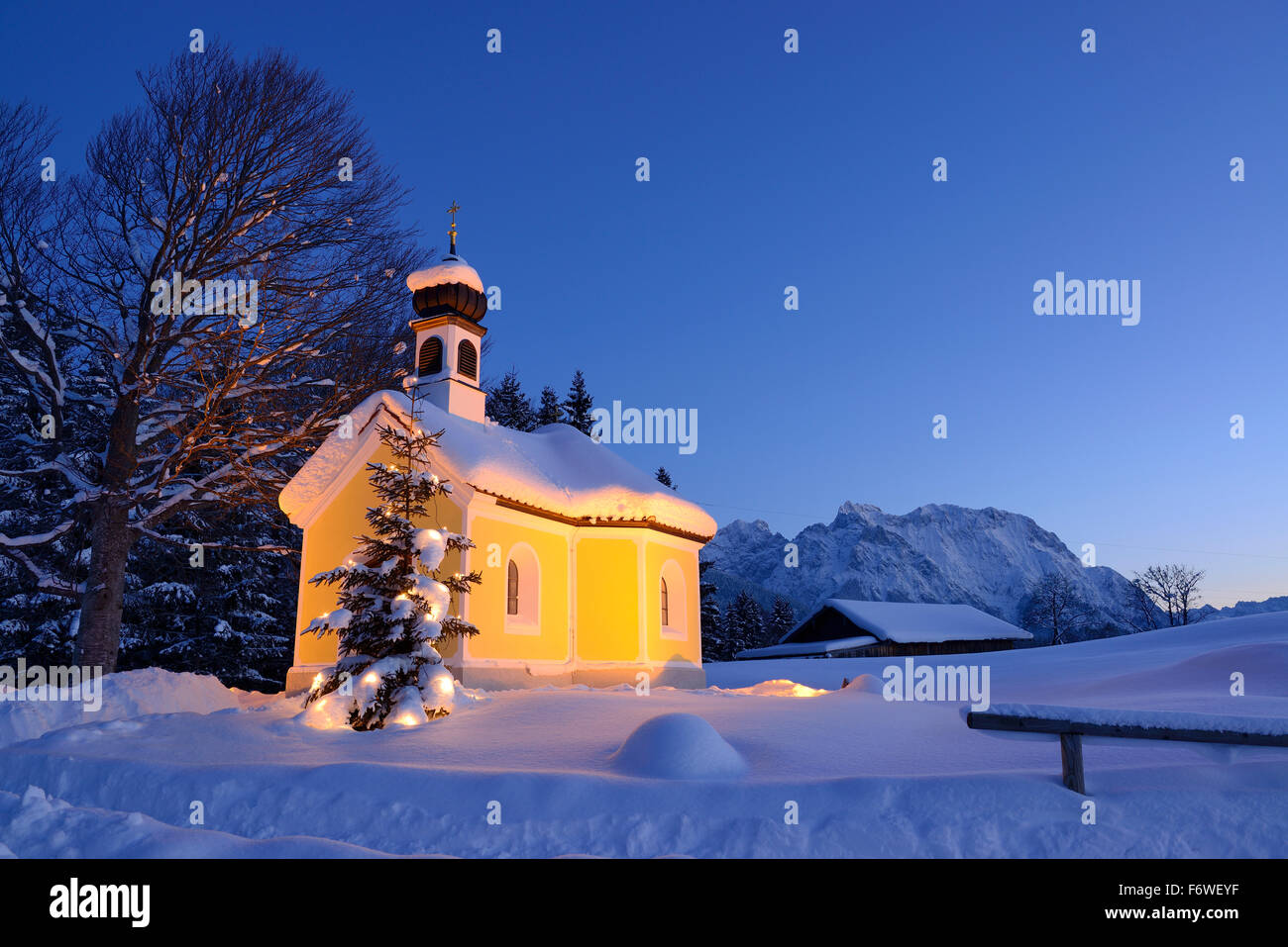 Snow-covered chapel with Christmas tree and Wetterstein range in background, Kruen, Werdenfels, Bavarian Alps, Upper Bavaria, Ba Stock Photo