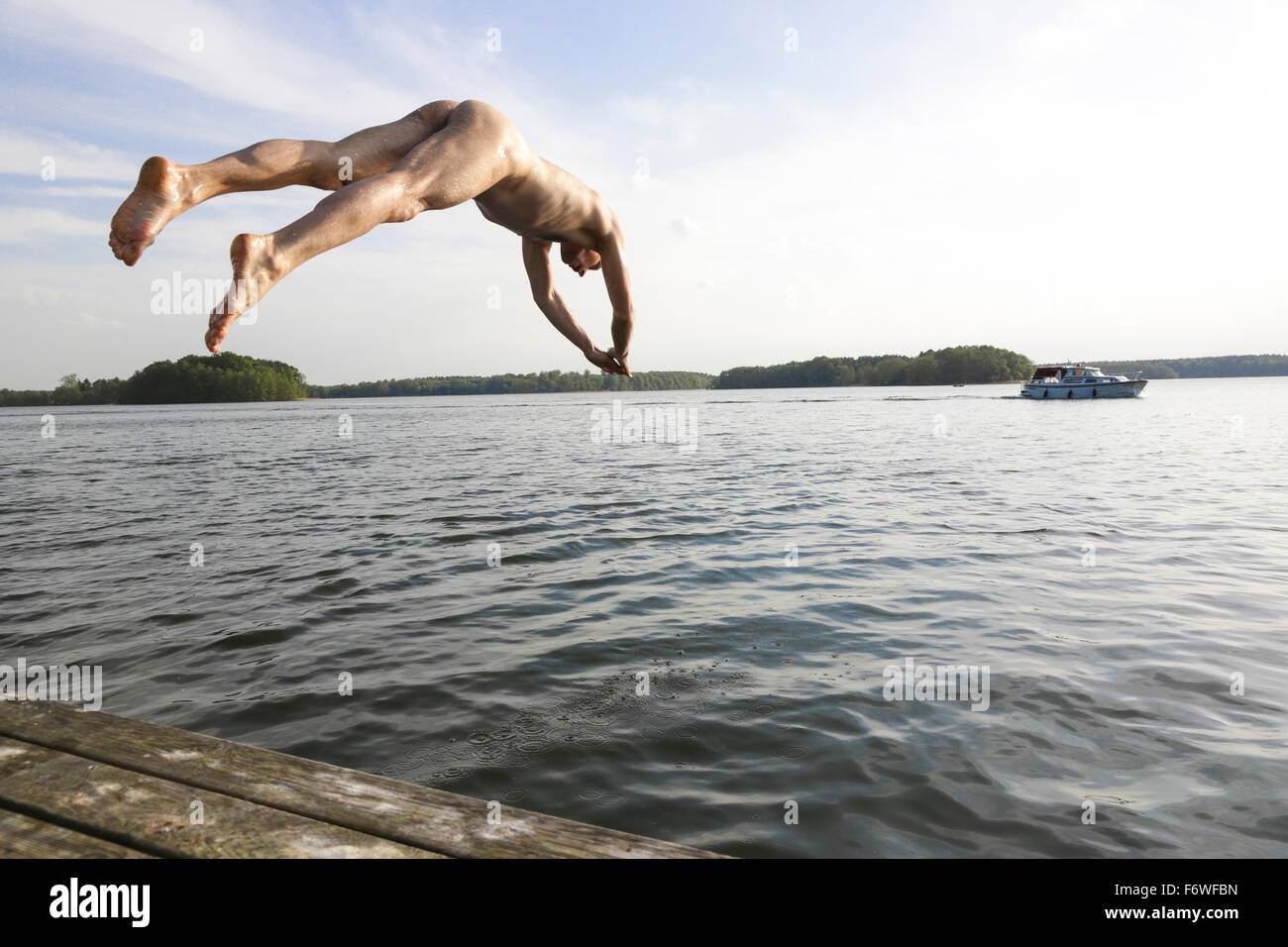 Naked man jumping into a lake, Lychen, Uckermark Lakes Nature Park, Uckermark, Brandenburg, Germany Stock Photo