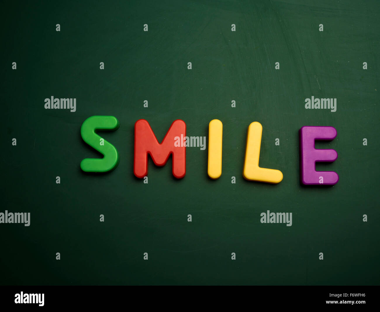 smile concept in colorful letters isolated on blank blackboard Stock Photo