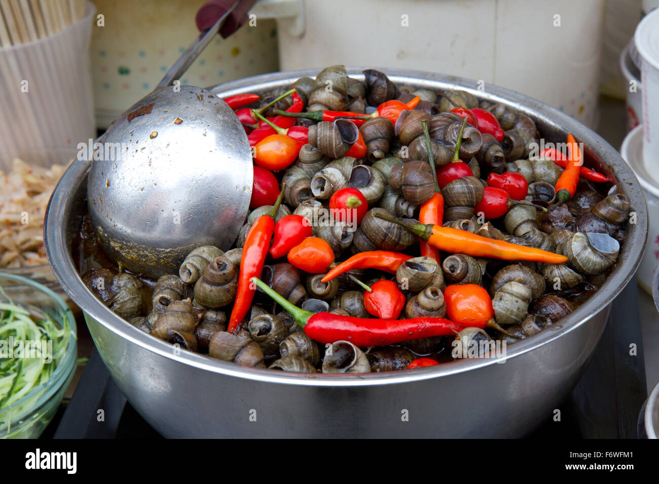 Chinese snails eaten with whole chili peppers Stock Photo Alamy