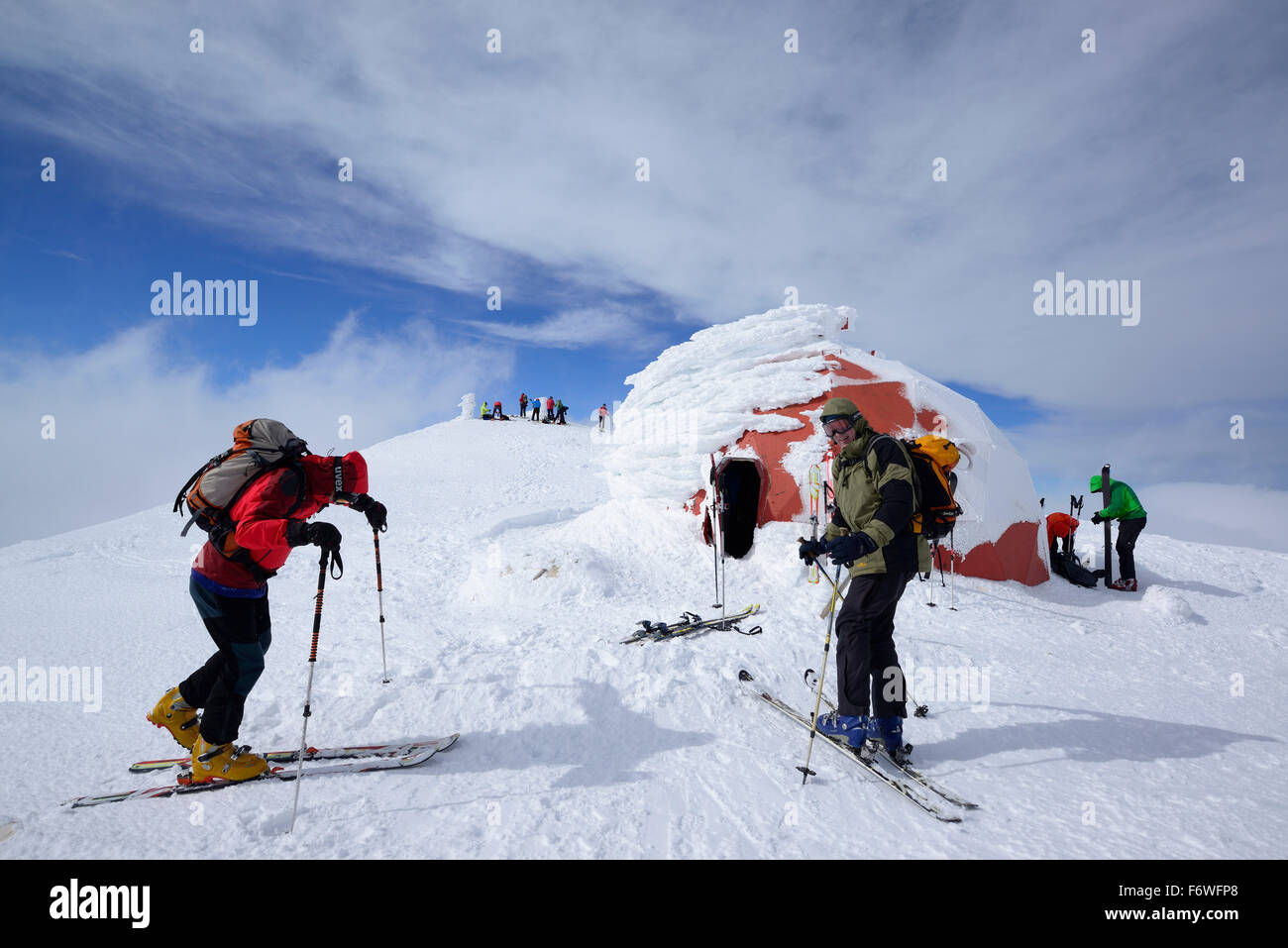 Group of persons back-country skiing standing on the summit of Monte Amaro with snow-covered bivouac, Monte Amaro, Majella, Abru Stock Photo