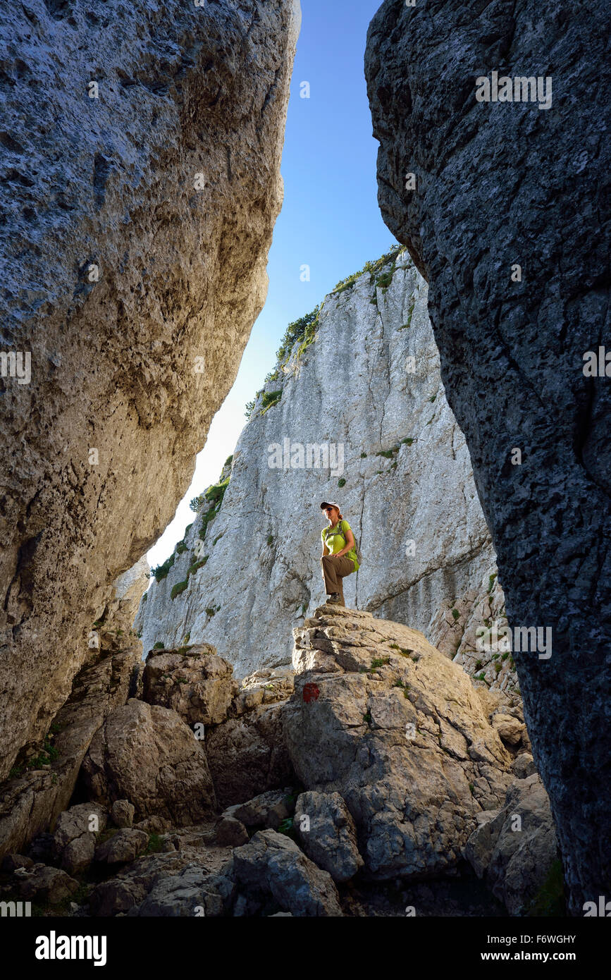 Woman standing on boulder in canyon Kaisersaele, Kampenwand, Chiemgau Alps, Chiemgau, Upper Bavaria, Bavaria, Germany Stock Photo