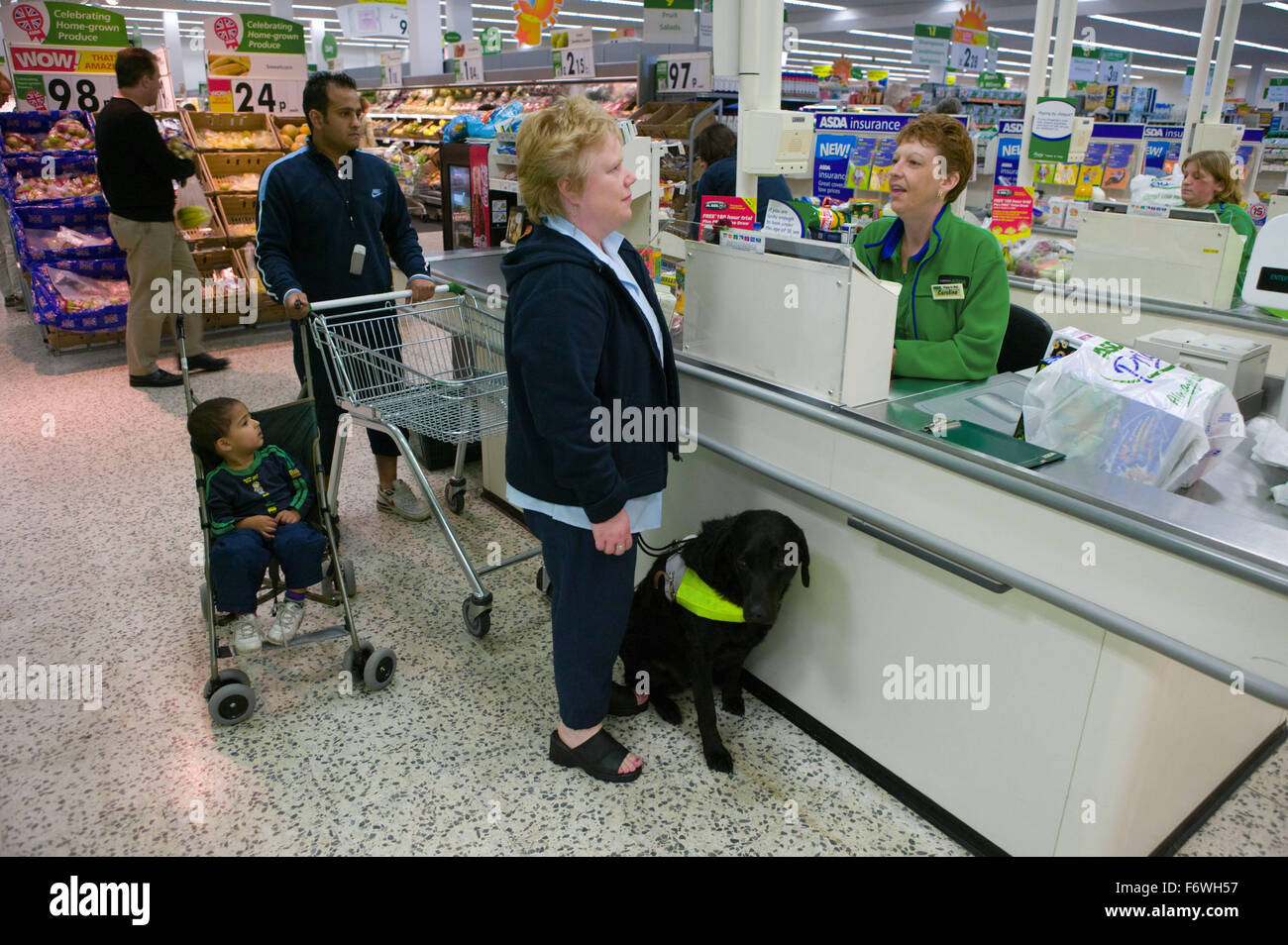 Woman with a visual impairment and her Guide dog at the checkout desk