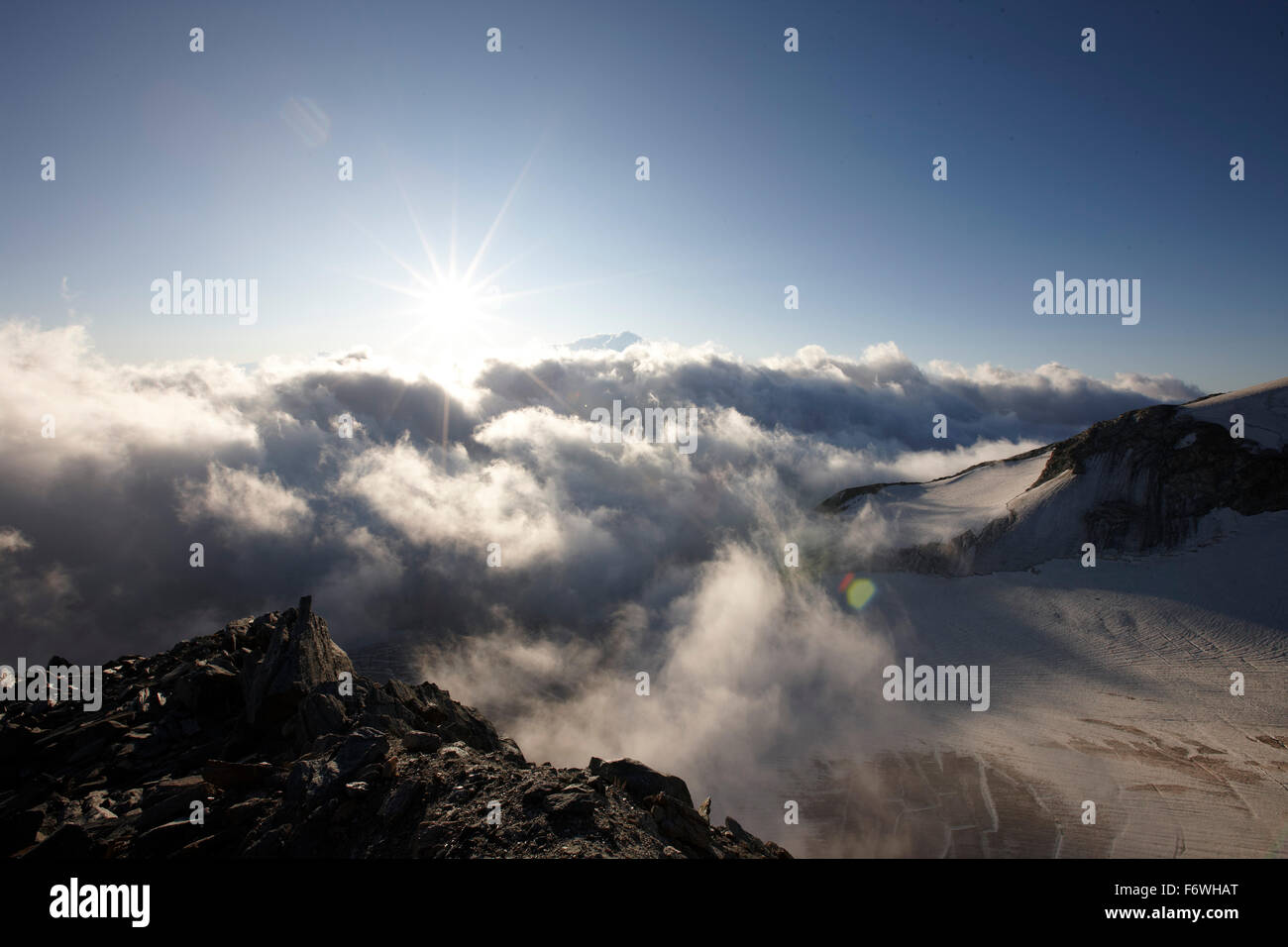 View over cloud-covered valley in sunrise, Saas-Fee, Canton of Valais, Switzerland Stock Photo