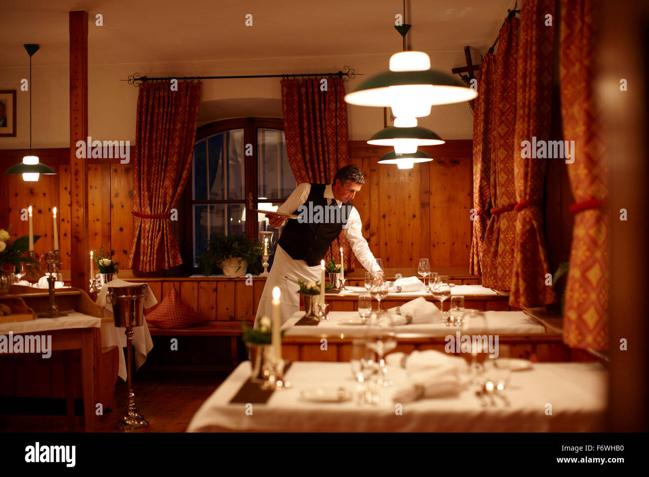 Waiter setting a table in a restaurant, Karthaus, Schnalstal, South Tyrol, Alto Adige, Italy Stock Photo