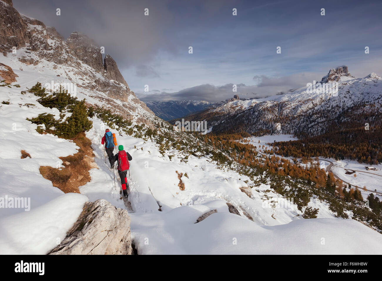 Young couple with backpacks hiking in snow, Fanes-Sennes-Prags Nature Park, valley of the Passo di Falzarego, the Dolomites, Bel Stock Photo