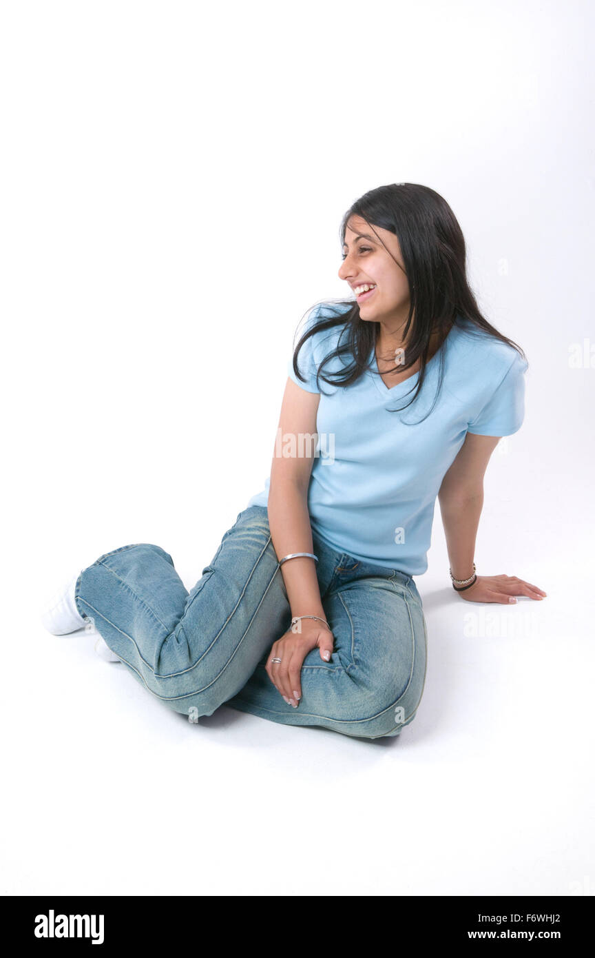 Portrait of a teenaged girl sitting on the floor smiling Stock Photo ...