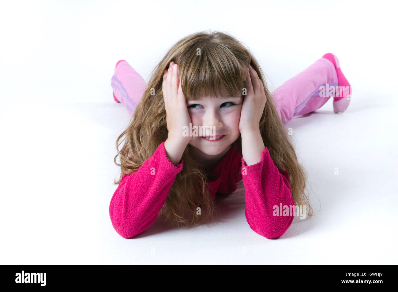 Little girl lying on her front with her head in her hands Stock Photo ...