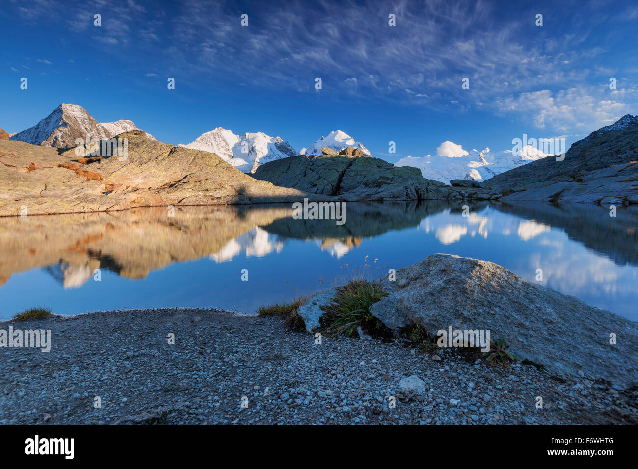 Reflection of Bernina Range on mountain lake, Val Roseg, Engadin, Canton of Grisons, Switzerland Stock Photo
