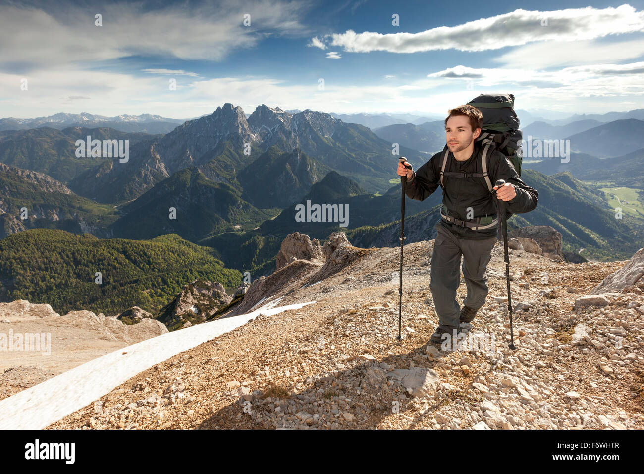 Young man with backpack ascending to Grosser Buchstein, Gesause National Park, Ennstal Alps, Styria, Austria Stock Photo