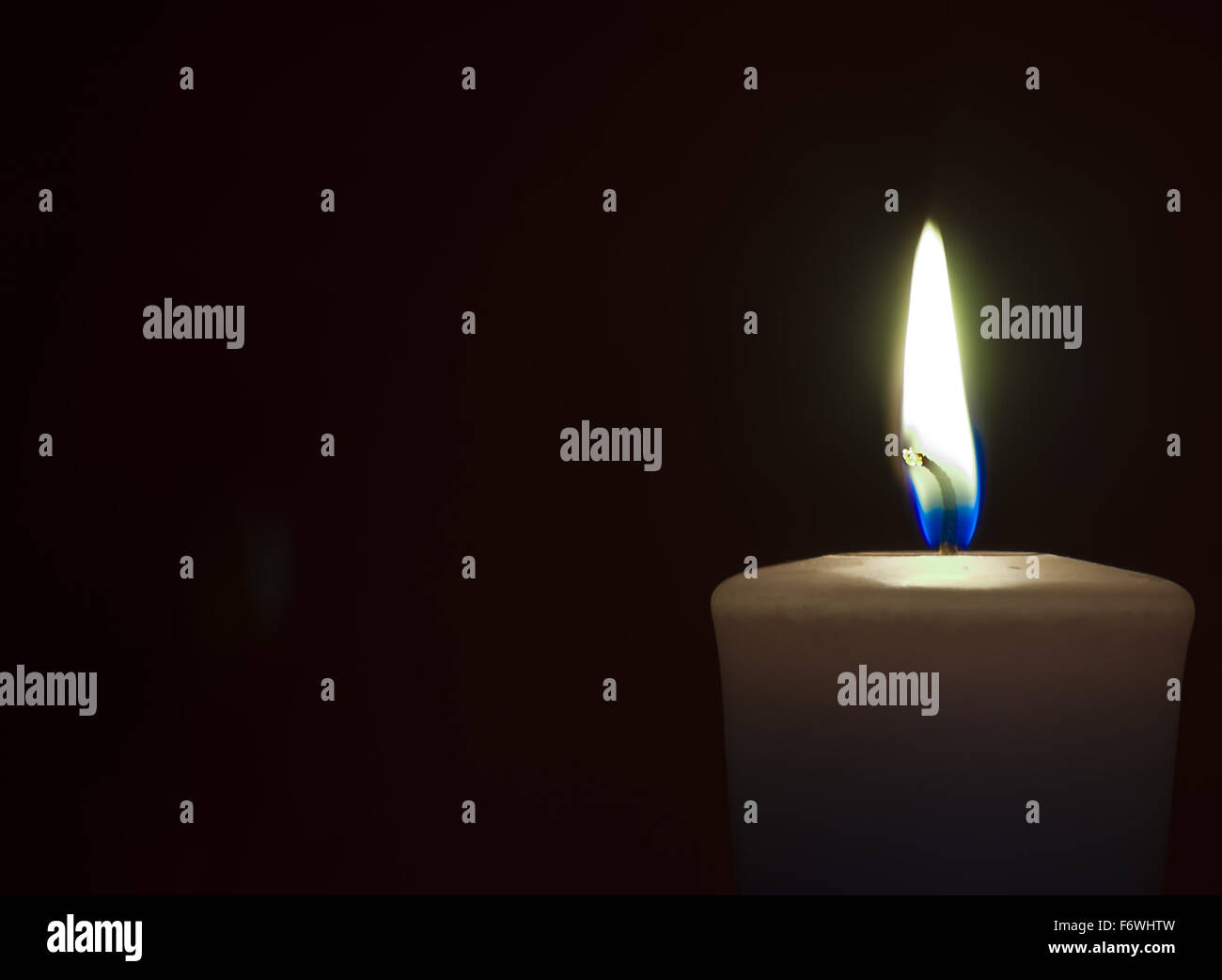 Isolate burning candle on dark background Stock Photo