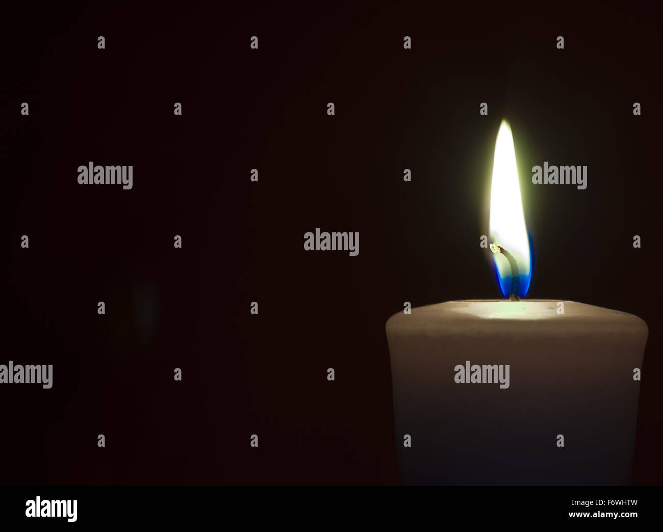 Isolate burning candle on dark background Stock Photo - Alamy