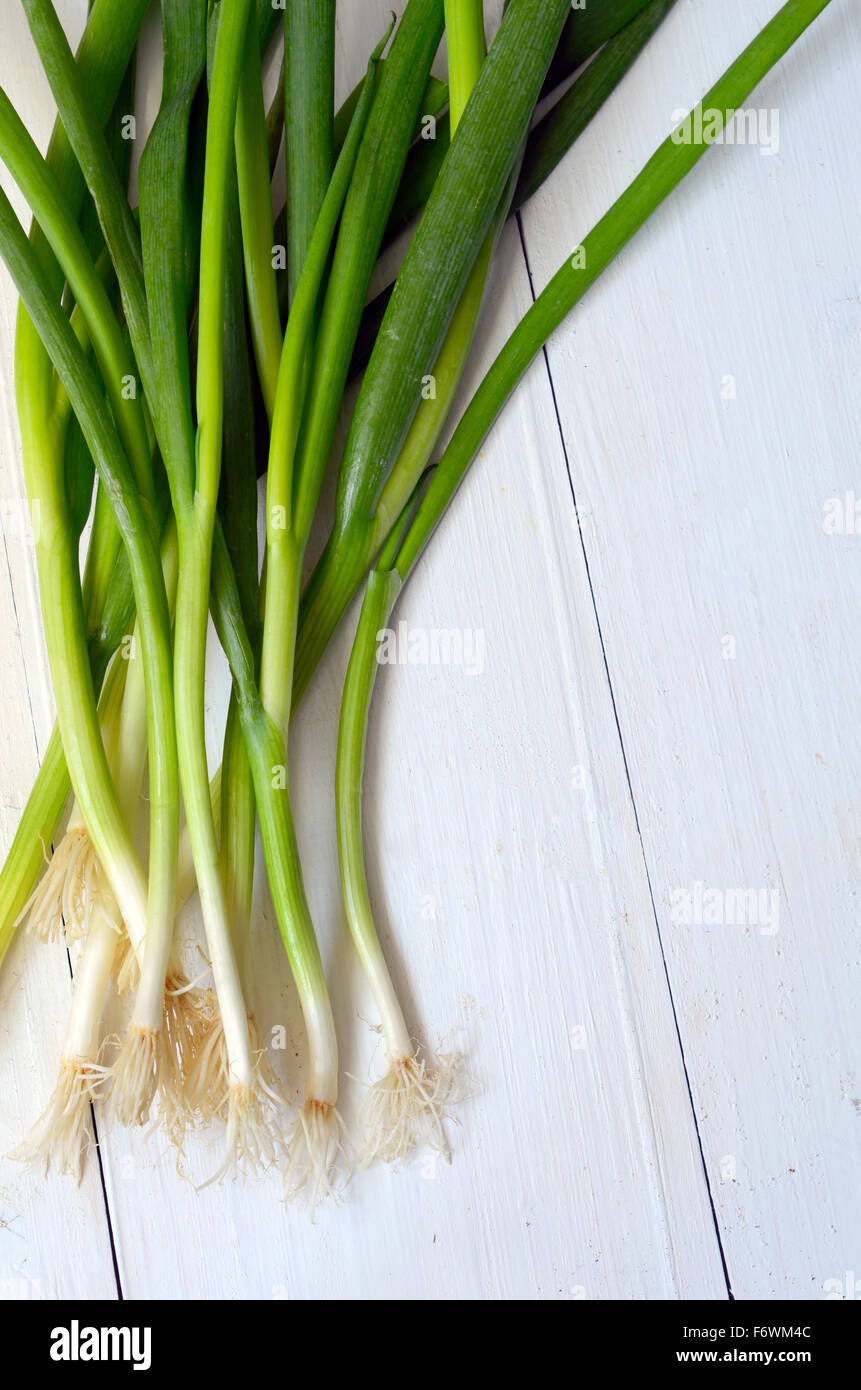 bunch of fresh green onions on wood Stock Photo