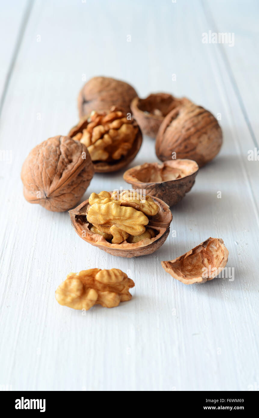 Walnut kernels and whole walnuts on rustic old wooden table Stock Photo