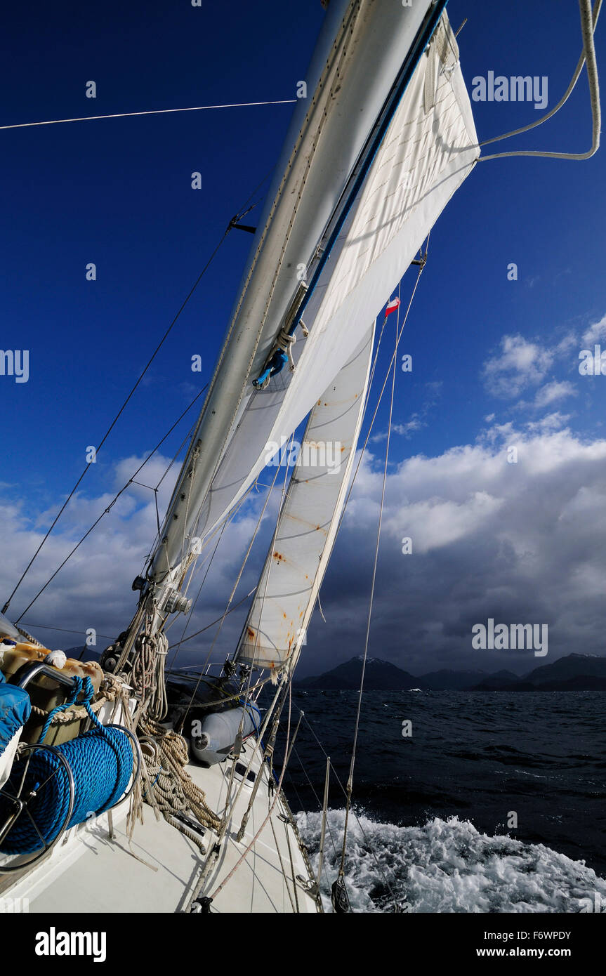 Boat in full sail passing Brecknock Passage, Tierra del Fuego, Chile Stock Photo
