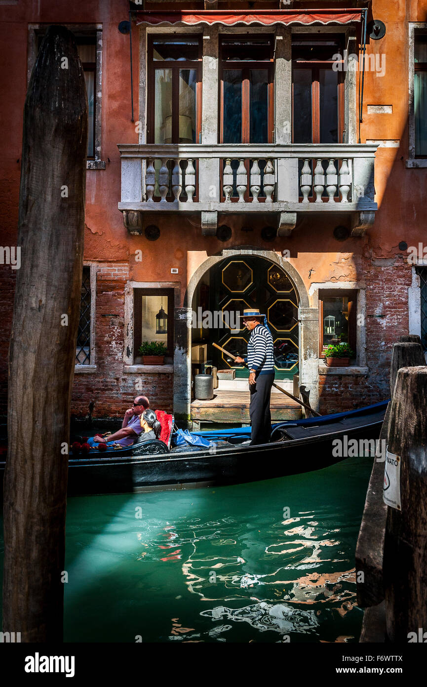 Tourists enjoying a ride in a gondola in Venice , Italy. Stock Photo