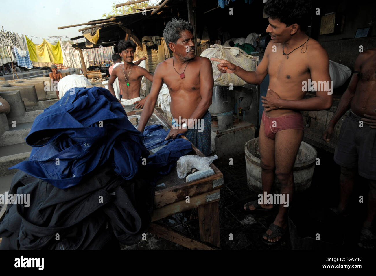 view of Dhobi Ghats around Mahalaxmi station where every day from dawn till dusk some 5000 dhobi-wallahs pound the city's laundry from hospital sheets to up market hotels. Row upon row of open air concrete wash pens each fitted with its own flogging stone.Clothes are first flogged then tossed into vats of boiling starch and then finally hung out to dry they are washed in any one of 7 types of chemical baths according to fabric type. Heavy wood burning irons are used for pressing. Stock Photo