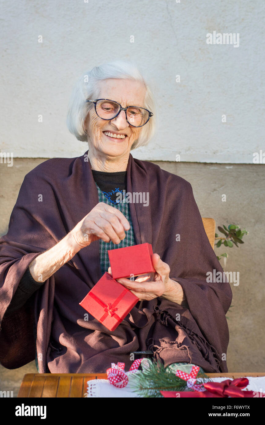 Happy ninety years old grandma receiving her Christmas present Stock Photo