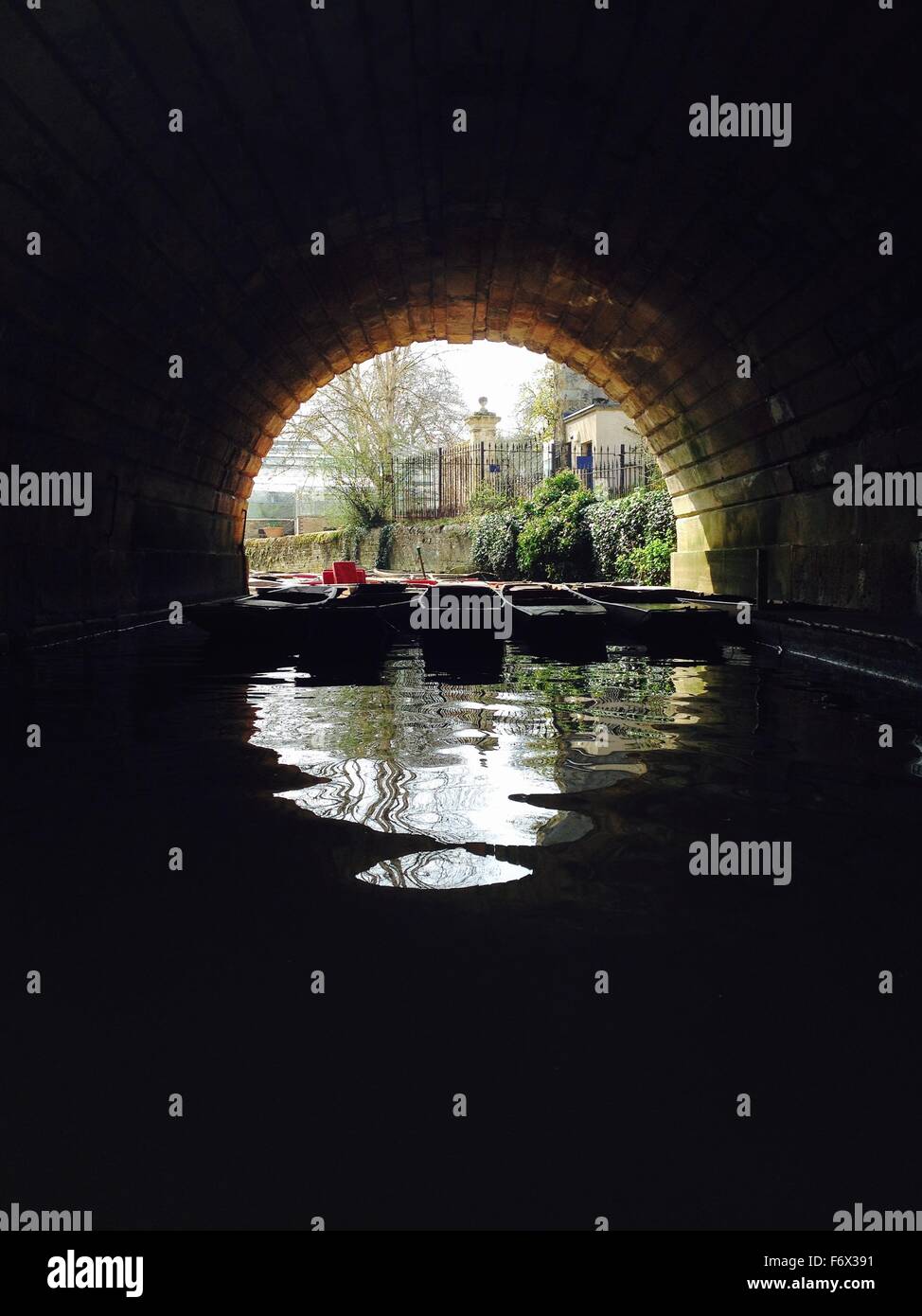 punting boats floating together beneath bridge Stock Photo