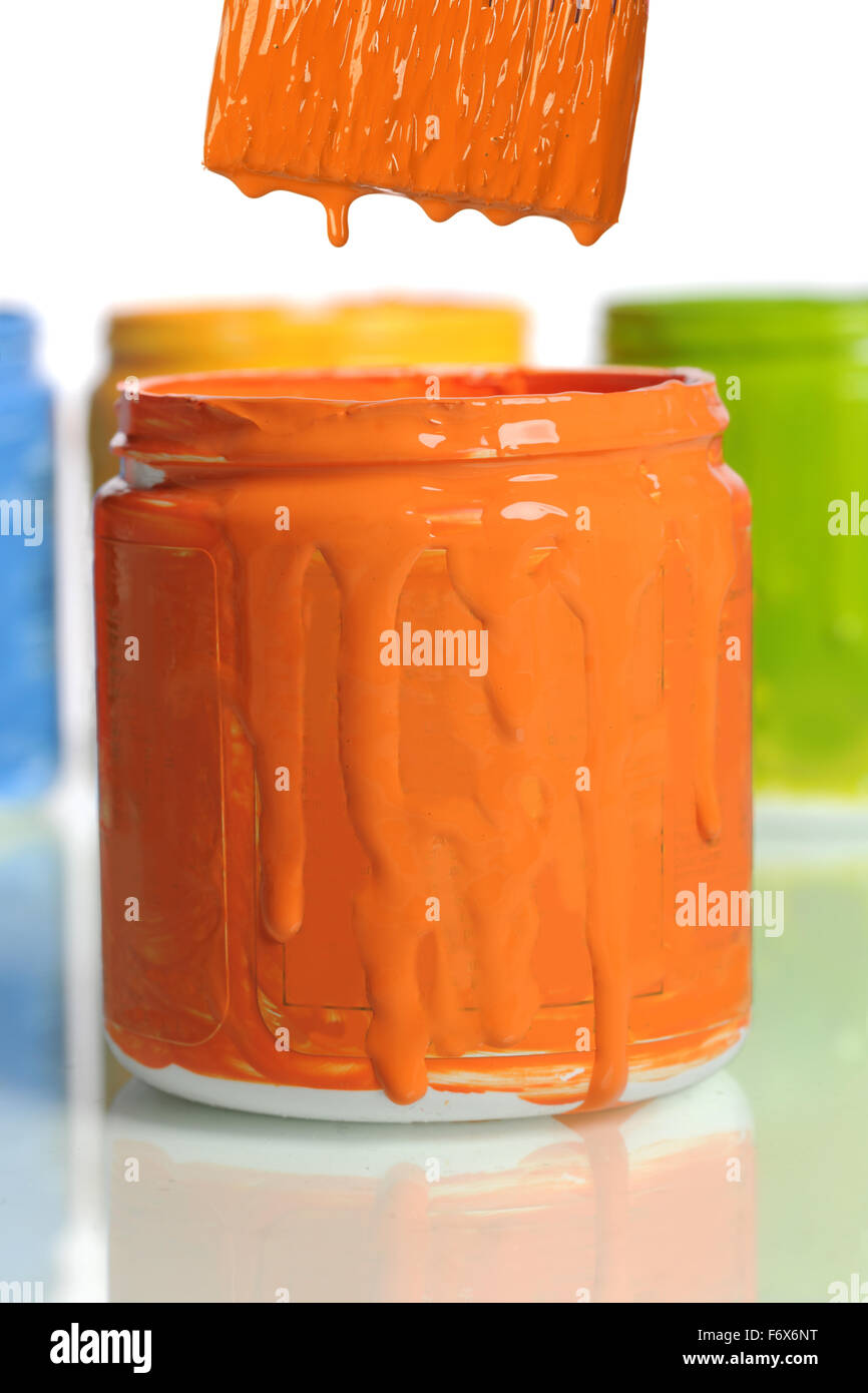 Can of orange paint in front of other containers isolated over white background Stock Photo