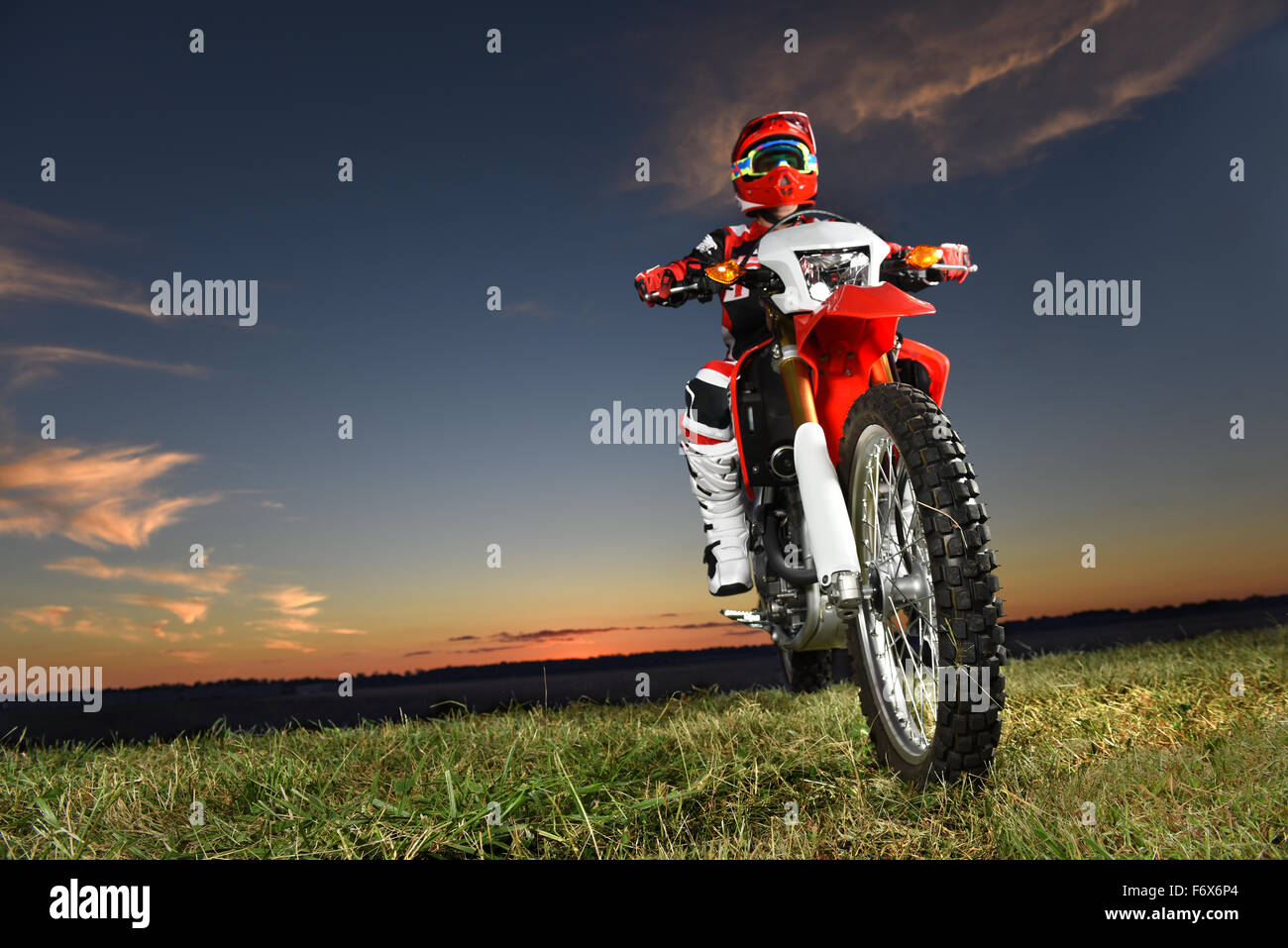 Man riding motocross bike at sunset - With copy space Stock Photo
