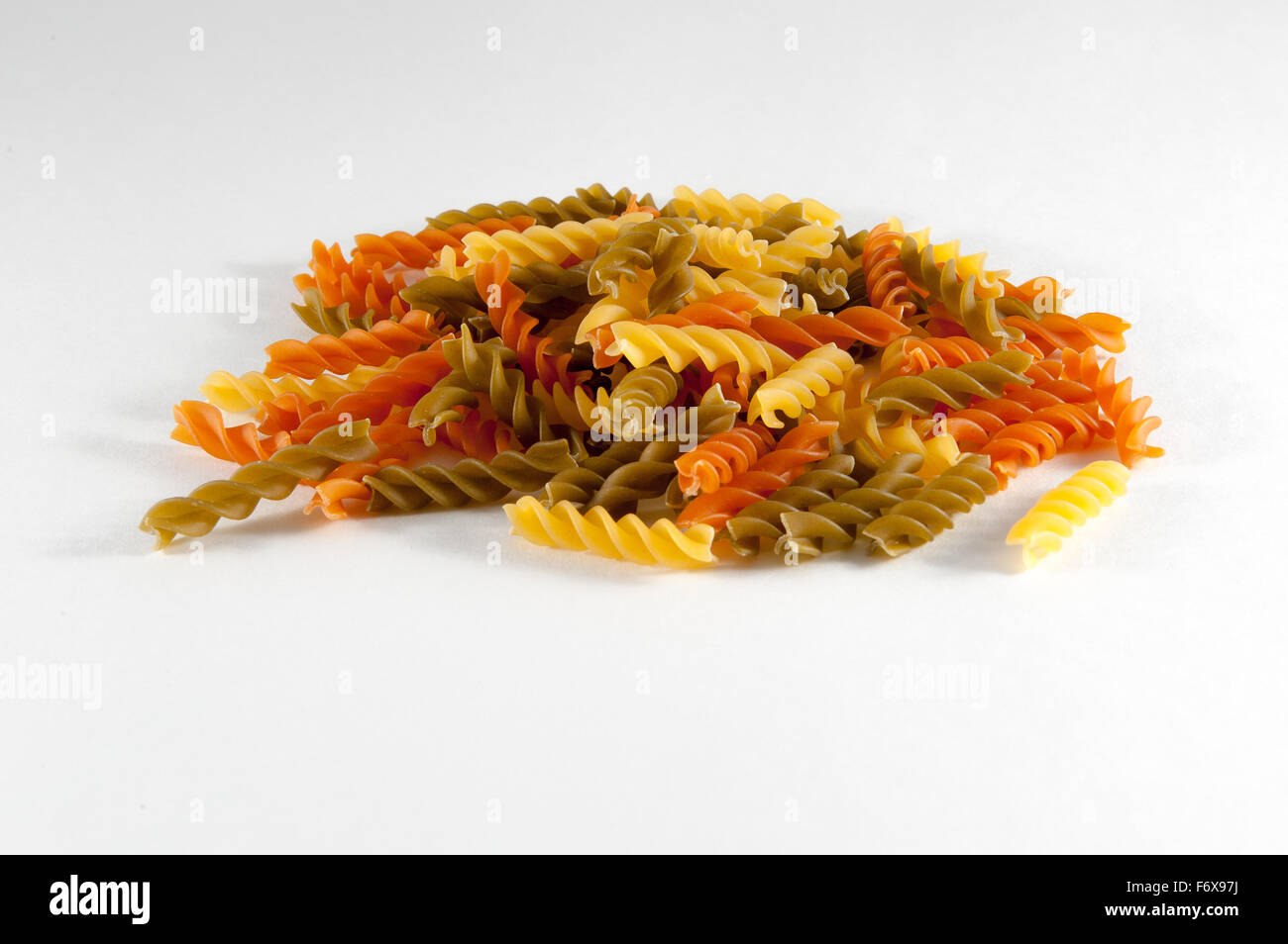 Uncooked coloured Rotini Pasta against a white background Stock Photo Alamy