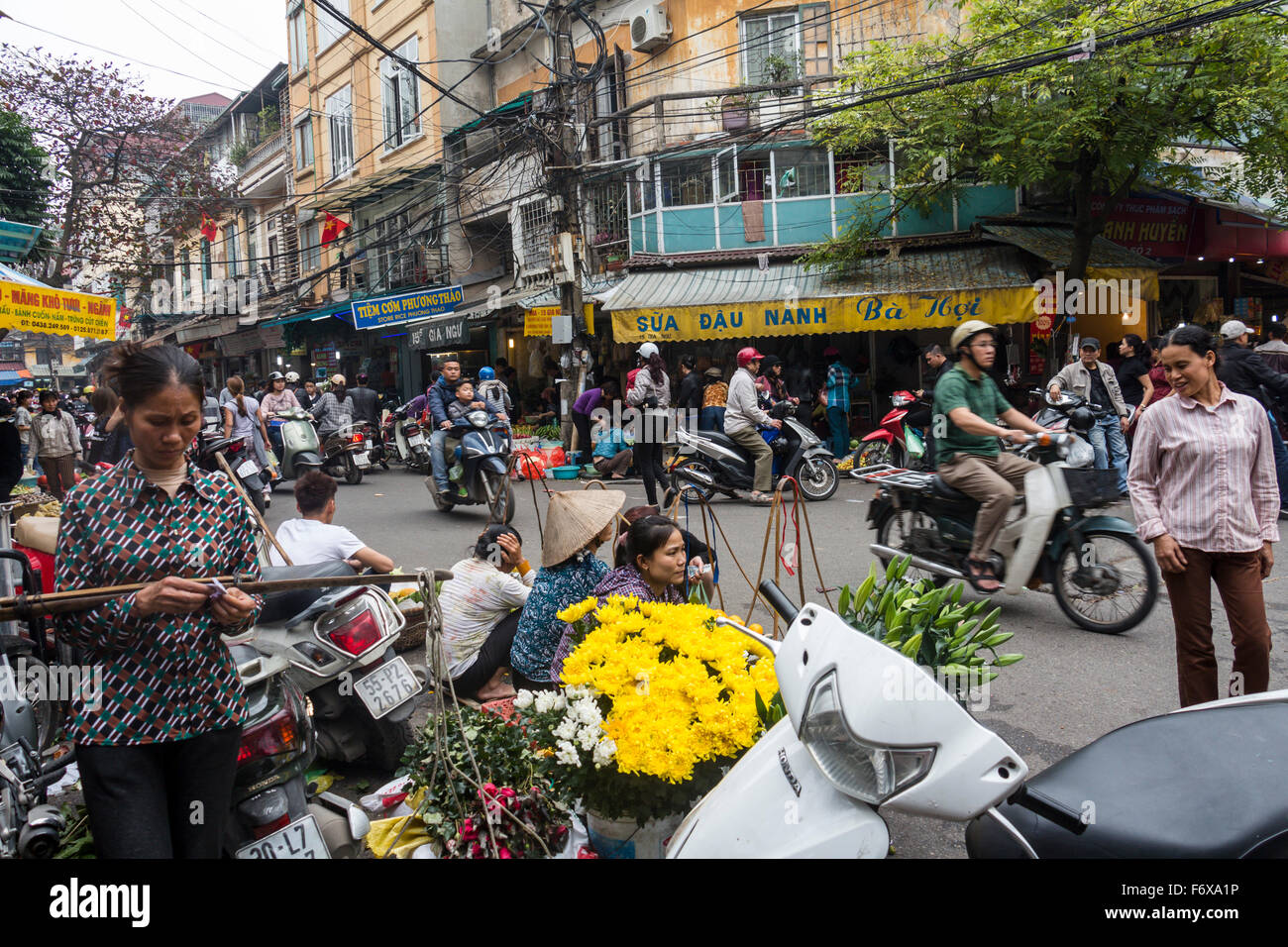 HANOI - FEBRUARY 17, 2015: Street food selling and little markets in the small streets of old town, Hanoi City in Vietnam. Locals are buying food for the next day which was a holiday. Stock Photo