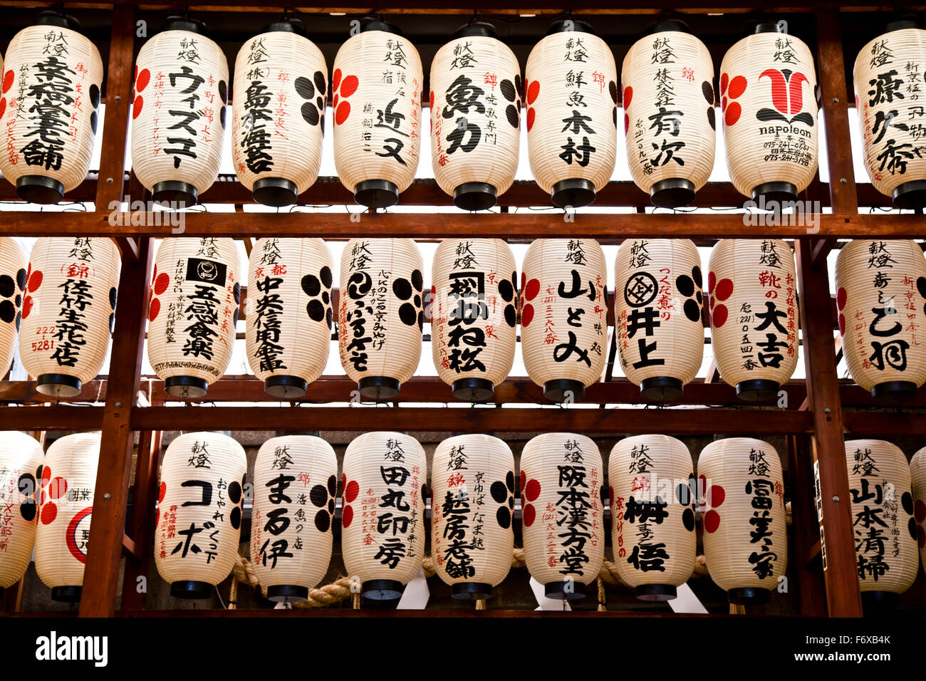 Paper lanterns hanging in a row with Japanese script; Kyoto, Japan Stock Photo