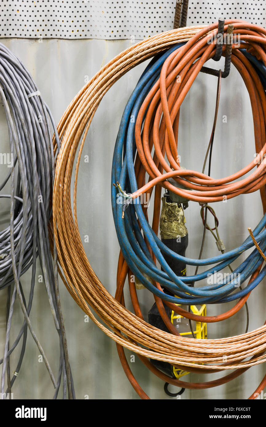 Coils of cable and cord hanging on a wall at an electrical power plant