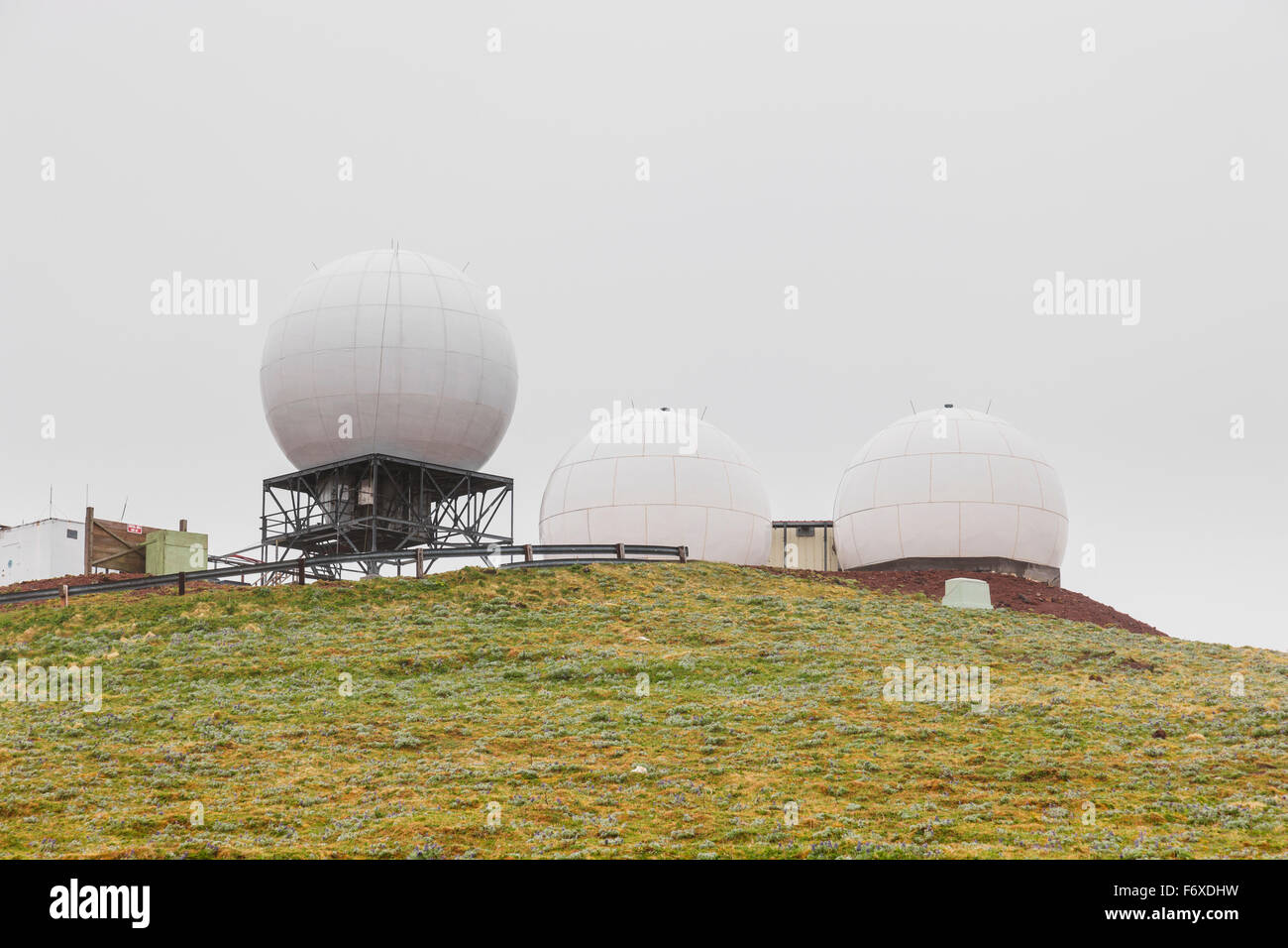 Three radar domes sit atop a green tundra hillside, St. Paul Island ...