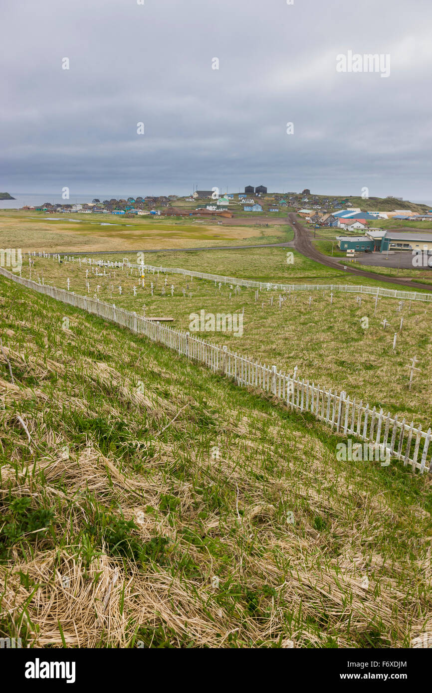 A weathered picket fence surrounds the grave crosses in the cemetary