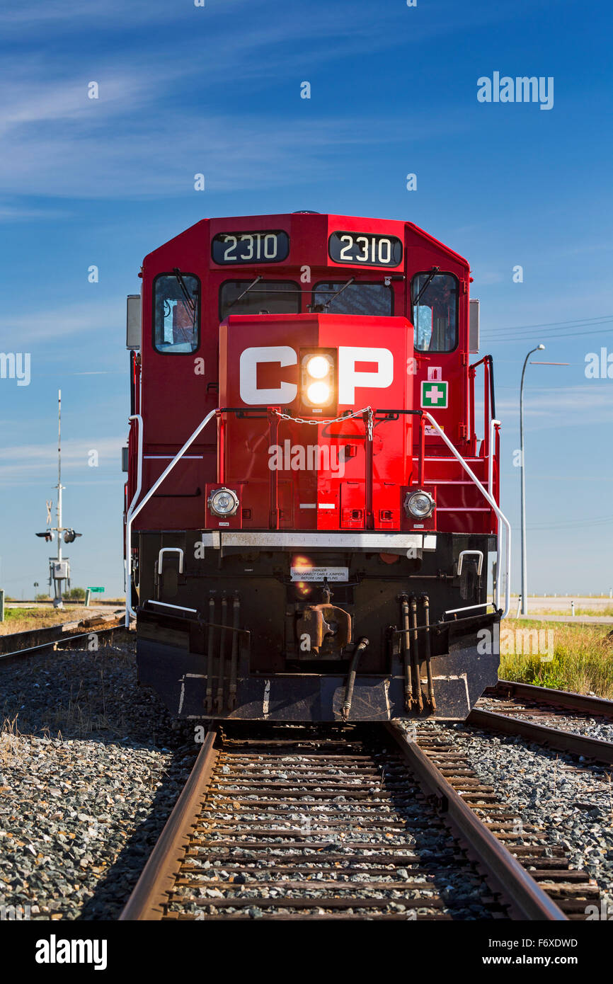 Front of a red train engine straight on the tracks; Crossfield, Alberta, Canada Stock Photo