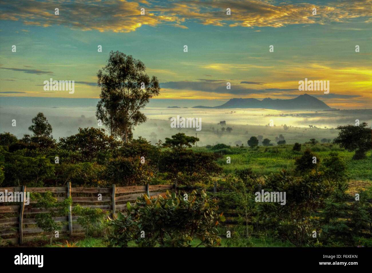 Early morning mist covers Chiphazi village as the sun rises over Dedza valley near Dedza, Malawi, Africa Stock Photo