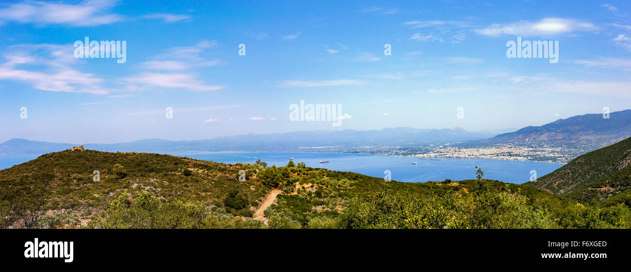 Distant city of European city in Greece against a blue sky and dreamy clouds, landscape photo taken on top of a hill Stock Photo