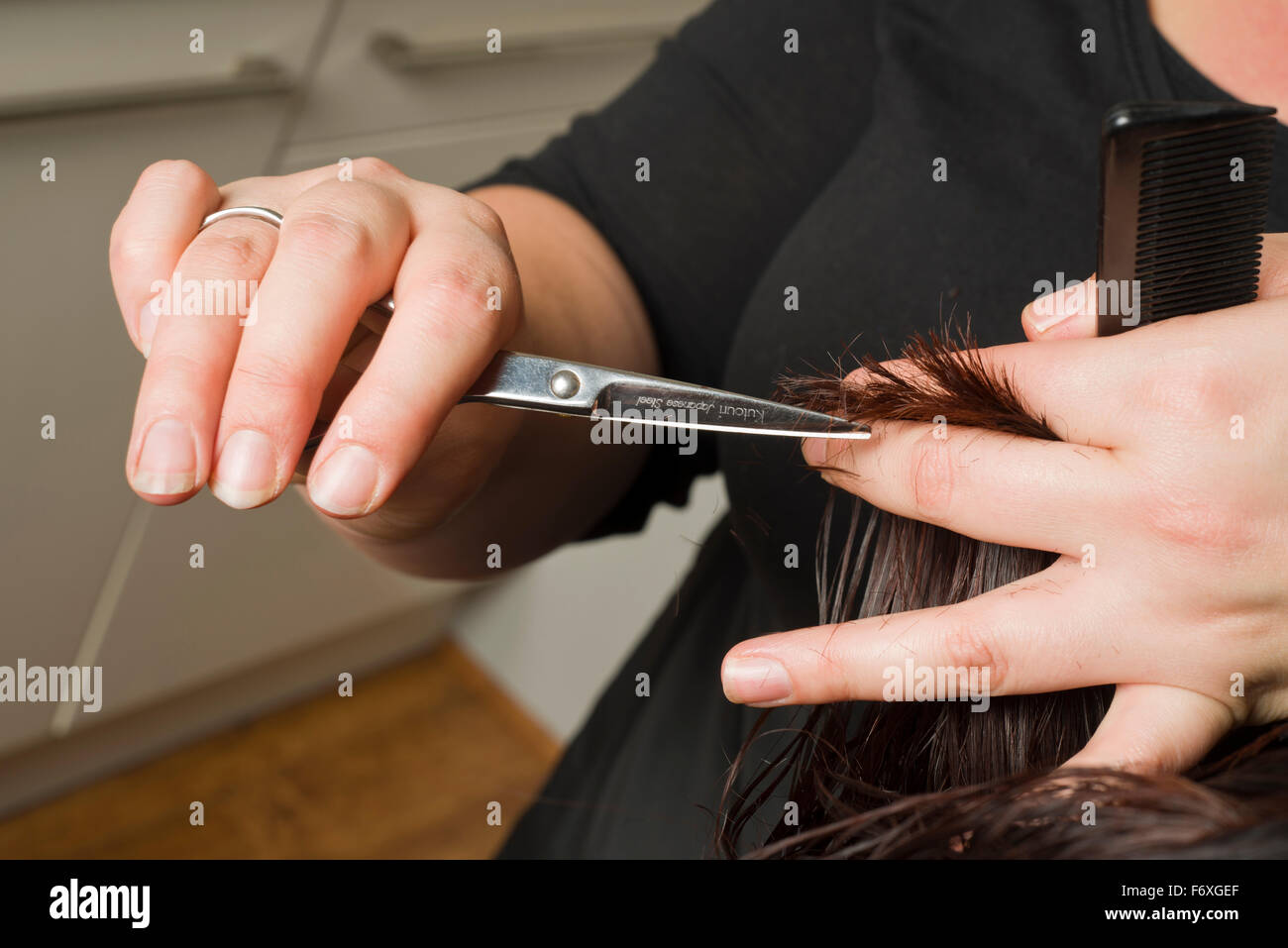 Home hairdresser visit. Traveling hair stylist who comes to your home to cut, style or colour ones hair. Stock Photo