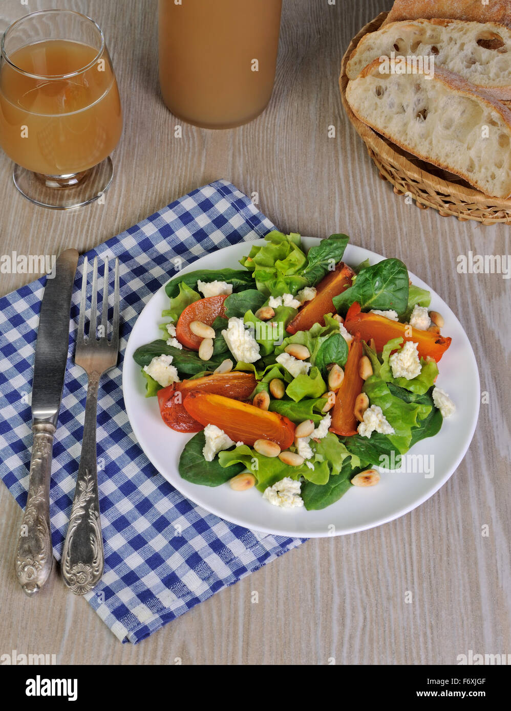 Fresh salad mix with persimmons, feta cheese and peanuts Stock Photo