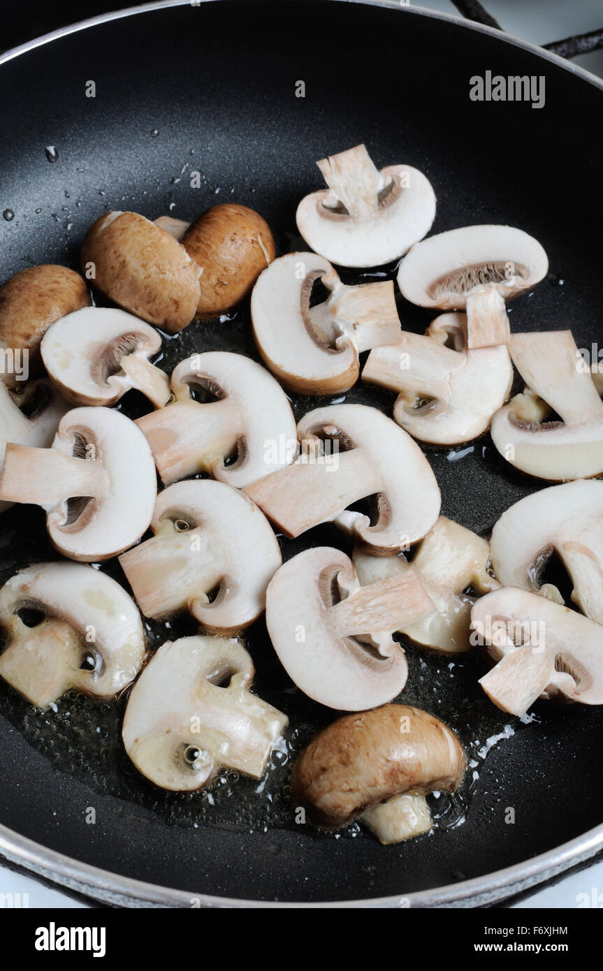 Fried sliced mushrooms in butter in a frying pan. For step by step