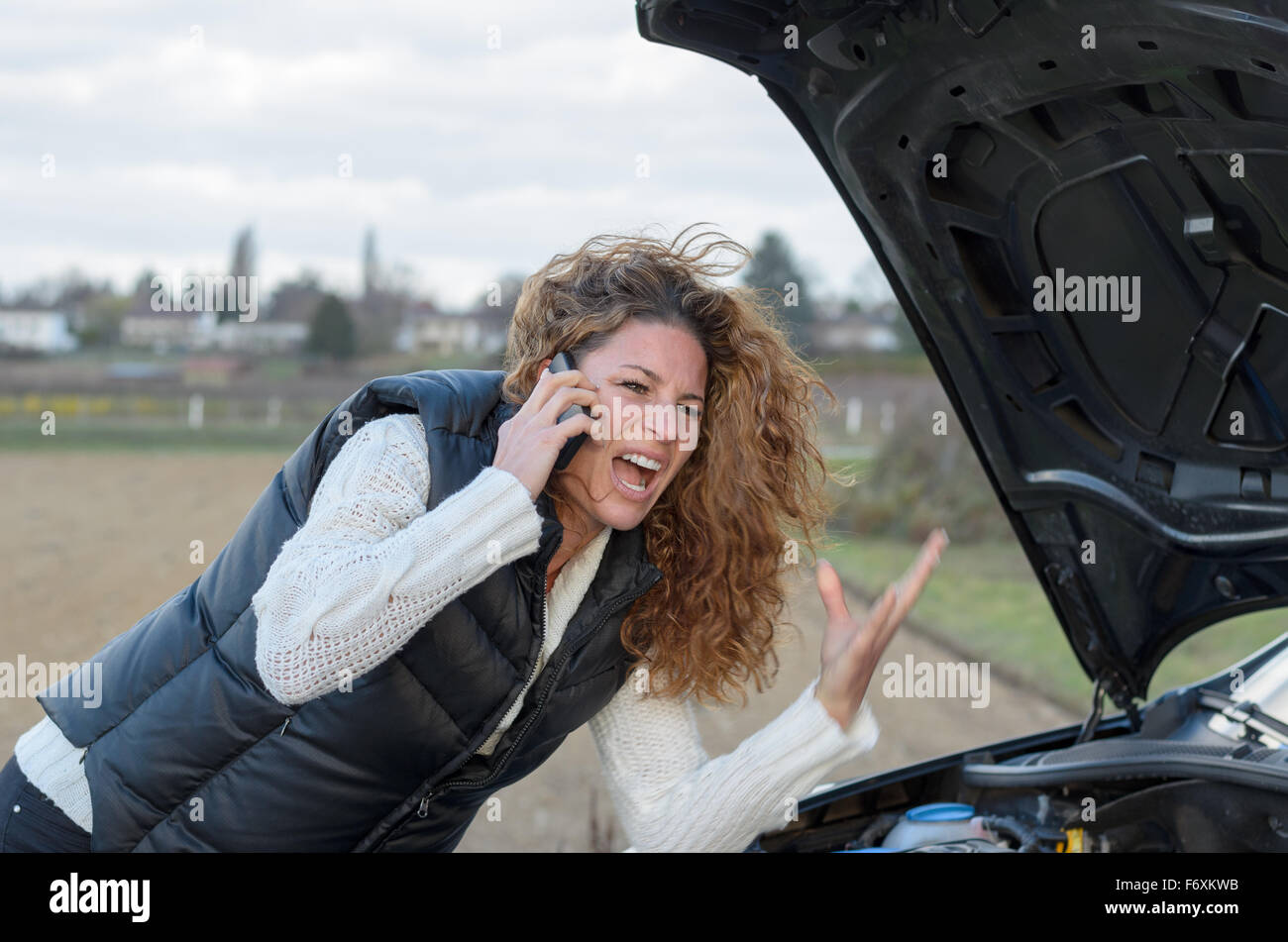 woman 's car breaks down and she is calling the emergency services Stock Photo