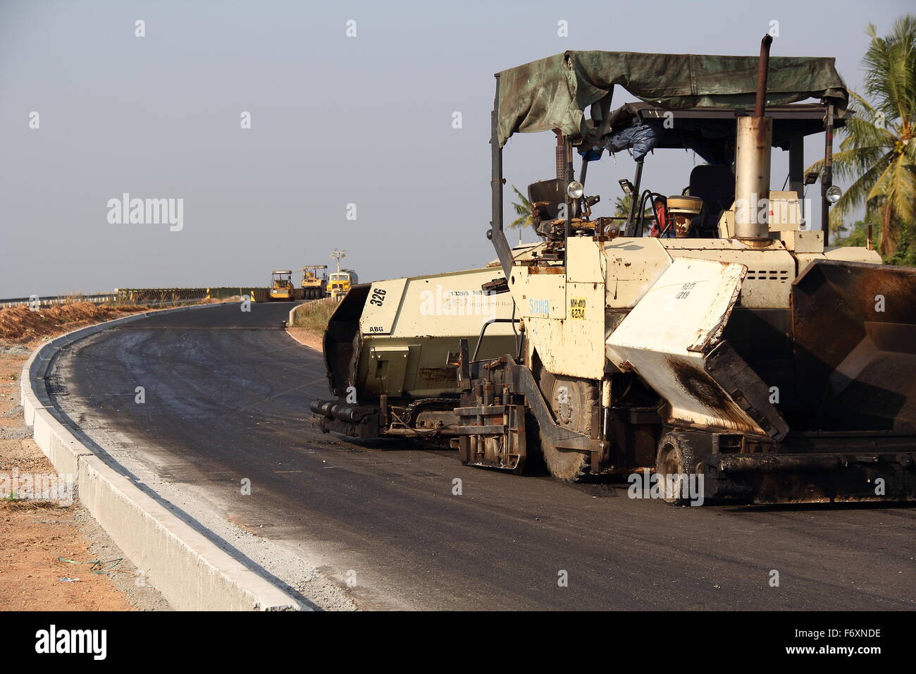 A newly constructed road and its tarring work is going on.Machinery