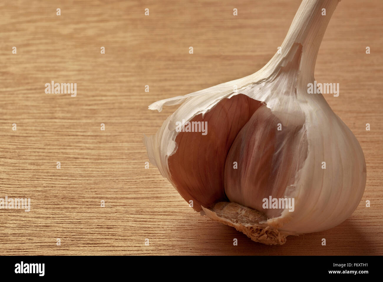 single garlic clove shot on a wooden background Stock Photo - Alamy