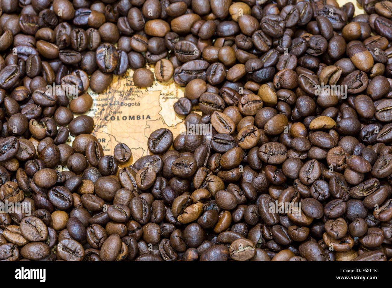 Vintage map of Colombia covered by a background of roasted coffee beans. This nation is the third main producer and exporter of Stock Photo