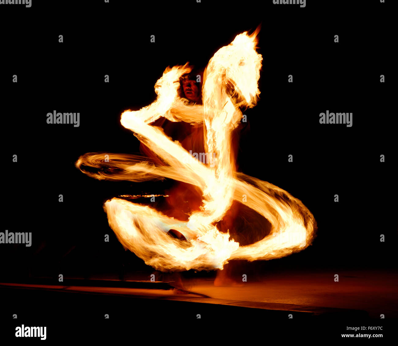 Luau fire dancer stage performance at night with flaming baton looks like fire dragon Maui Hawaii Stock Photo