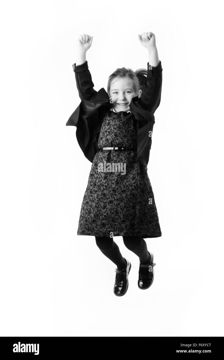 young girl dressed up as a business person jumping up in the air for joy Stock Photo