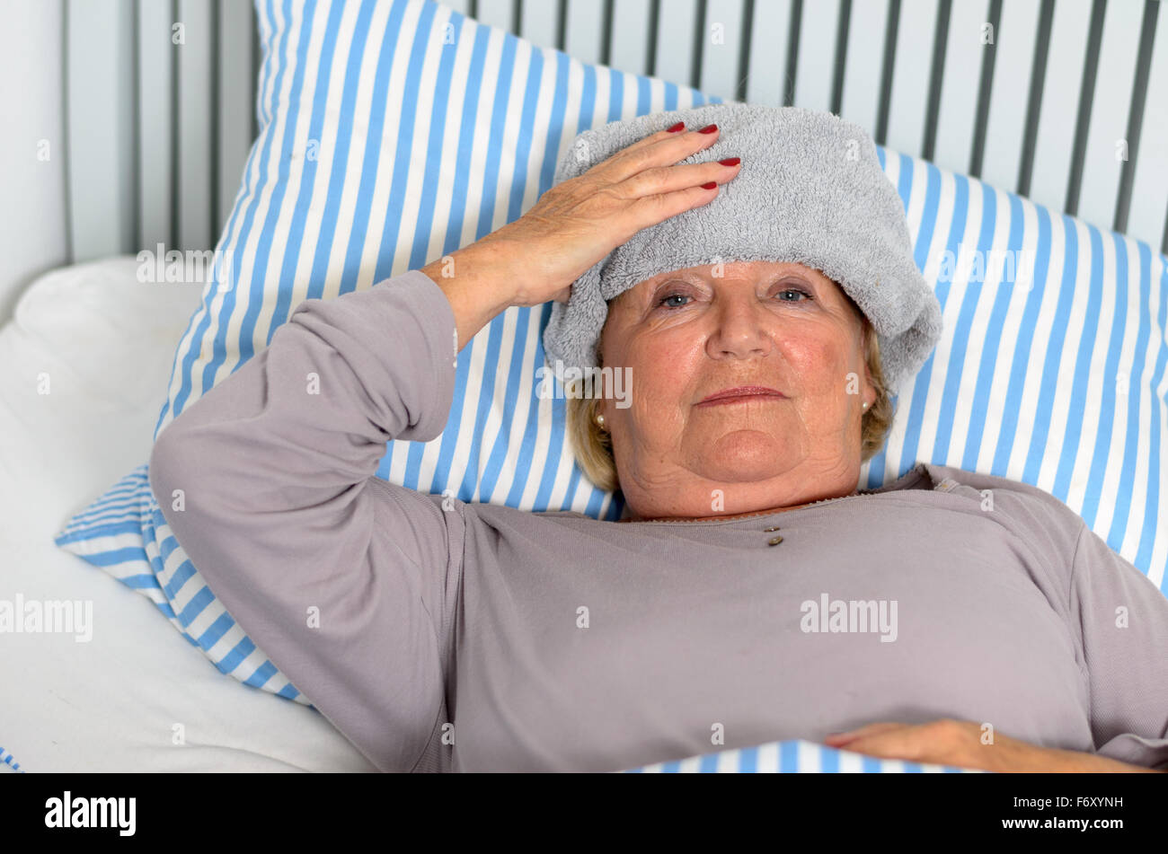 Полотенце на лоб. Женщина с полотенцем на лбу. Больная женщина лежит с полотенцем на голове. Больной с полотенцем на лбу фото. Лежит с полотенцем на лбу.